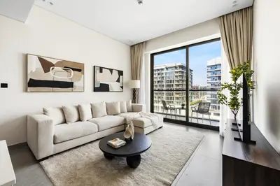a living room with a white couch and a large window at Stylish 1BR Retreat Near World Trade Center Metro in Dubai