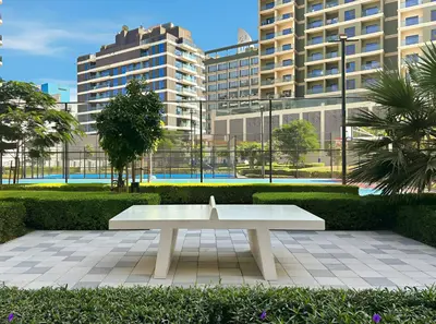 a white bench in a park with tall buildings at Stylish 1BR Retreat Near World Trade Center Metro in Dubai