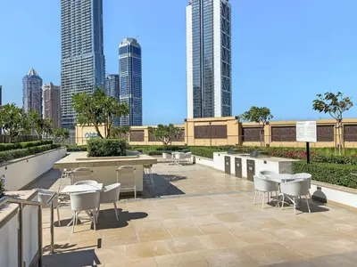 a patio with tables and chairs and tall buildings at Breathtaking 1 BDR w Partial Burjkhalifa View in Dubai