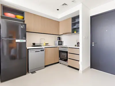 a kitchen with stainless steel appliances and wooden cabinets at Breathtaking 1 BDR w Partial Burjkhalifa View in Dubai