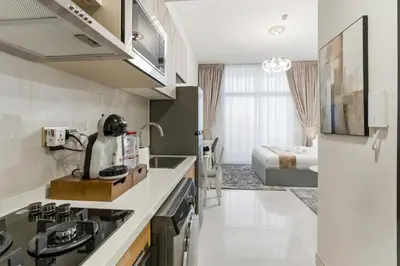 a kitchen with a sink and a bed in a room at Modern Studio on 27th Floor with Miracle Garden Views in Dubai