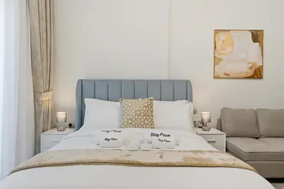 a bedroom with a bed and a couch at Modern Studio on 27th Floor with Miracle Garden Views in Dubai