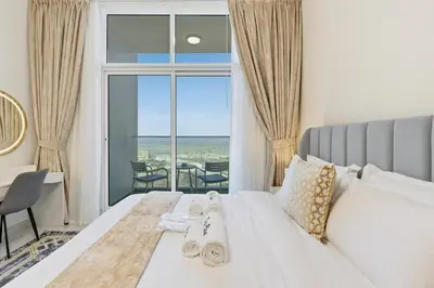 a bedroom with a bed with a view of the ocean at Modern Studio on 27th Floor with Miracle Garden Views in Dubai