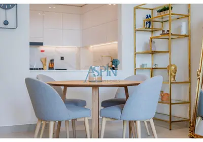 a wooden table with blue chairs in a kitchen at Aspin Brand New Cozy 1BR at Binghatti Lavender JVC in Dubai