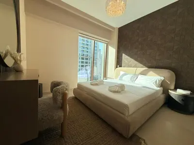 a bedroom with a white bed and a window at Luxury 2BR in Creek Beach with Lagoon Access in Dubai