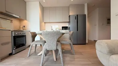 a kitchen with a table and chairs and a refrigerator at Luxury 2BR in Creek Beach with Lagoon Access in Dubai