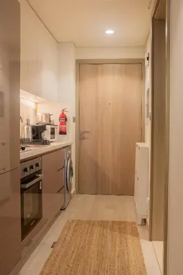 a kitchen with a wooden door in a kitchen at Cosy Modern Studio Downtown Dubai in Dubai