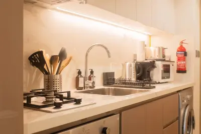 a kitchen counter with a sink and a microwave at Cosy Modern Studio Downtown Dubai in Dubai