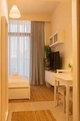 a small room with a bed and a table at Cosy Modern Studio Downtown Dubai in Dubai