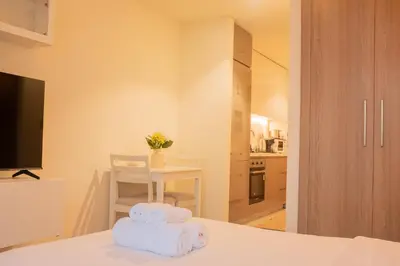 a bedroom with towels on a bed with a table at Cosy Modern Studio Downtown Dubai in Dubai