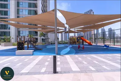 a playground with awning and a slide and swings at Vogue Downtown Views II with Direct Access to Dubai Mall Via a Climate Controlled Bridge, One Bedroom Apartment with Balcony and City View in Dubai