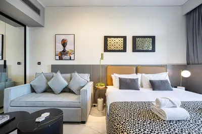 a hotel room with two beds and a couch at Luxury Canal View Studio for 4 Guests in Downtown, 5 Min to Dubai Mall in Dubai