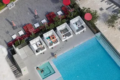 an overhead view of a pool with two people swimming at Luxury Canal View Studio for 4 Guests in Downtown, 5 Min to Dubai Mall in Dubai