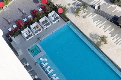 an overhead view of a swimming pool with chaises and chairs at Luxury Canal View Studio for 4 Guests in Downtown, 5 Min to Dubai Mall in Dubai