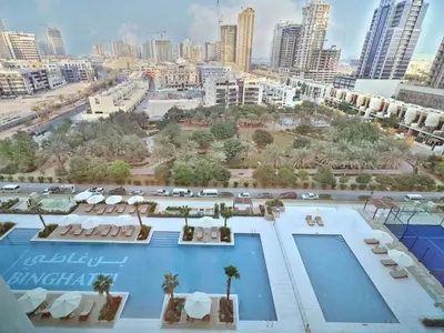 a view of a pool with a city in the background at Bright 1-Bed with Pool and Gym in Dubai