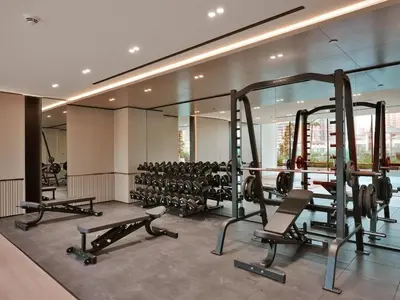 a gym with several tread machines in a building at Bright 1-Bed with Pool and Gym in Dubai