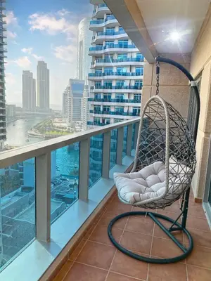 a chair on a balcony with a view of a city at OneBedroom Apartment with Partial Sea view in Dubai Marina - Z1106 in Dubai