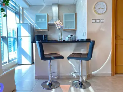a kitchen with a counter with two bar stools at Stylish Studio near the beach in Dubai Marina in Dubai