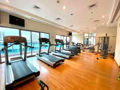 a gym with a row of treadmills and elliptical machines at Stylish Studio near the beach in Dubai Marina in Dubai