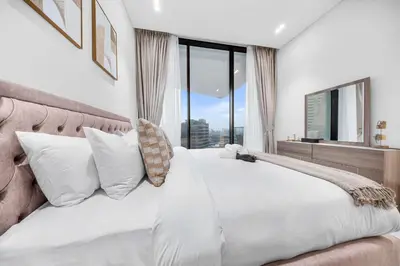 a bedroom with a white bed with a large window at StayShort - Modern 1 Bedroom with Private Jacuzzi in JVC that Sleeps 2 in Dubai