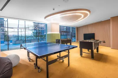 a ping pong table in a room with two tables at StayShort - Modern 1 Bedroom with Private Jacuzzi in JVC that Sleeps 2 in Dubai