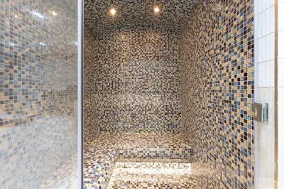 a bathroom with a shower with tiled walls at StayShort - Modern 1 Bedroom with Private Jacuzzi in JVC that Sleeps 2 in Dubai