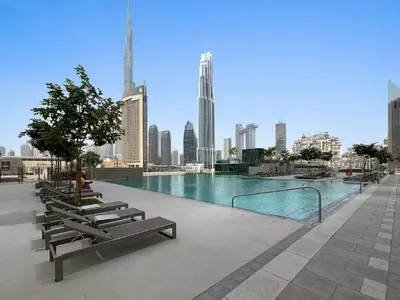 a swimming pool with benches and a city skyline at Vogue Downtown Views II with Direct Access to Dubai Mall Via a Climate Controlled Bridge, One Bedroom Apartment with Balcony and City View in Dubai