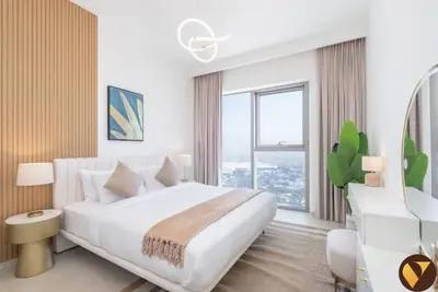 a white bedroom with a large bed and a large window at Vogue Downtown Views II with Direct Access to Dubai Mall Via a Climate Controlled Bridge, One Bedroom Apartment with Balcony and City View in Dubai