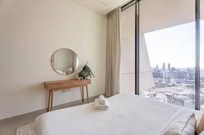 a bedroom with a white bed and a large window at GuestReady - Luxe Stay with Private Pool in Dubai