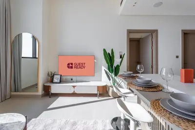a dining room with a table and chairs and a mirror at GuestReady - Luxe Stay with Private Pool in Dubai