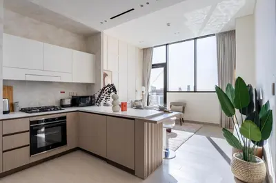 a kitchen with white appliances and a large window at GuestReady - Luxe Stay with Private Pool in Dubai