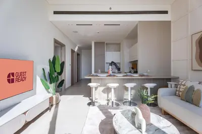 a living room with a couch and a kitchen at GuestReady - Luxe Stay with Private Pool in Dubai