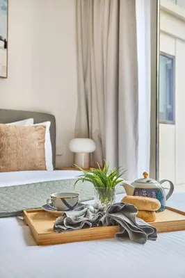 a table with a tray of food on a bed at Frank Porter - Grove at Creek Beach Building in Dubai