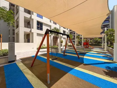 a playground with a swing set in a building at Frank Porter - Grove at Creek Beach Building in Dubai