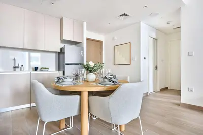 a kitchen and dining room with a wooden table and chairs at Frank Porter - Grove at Creek Beach Building in Dubai