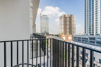 a balcony with a view of a city with tall buildings at Prime Location, Walking Distance to Circle Mall, Minutes Drive from Dubai Marina and Palm Jumeirah - Binghatti Aurora, JVC by Deluxe Holiday Homes in Dubai