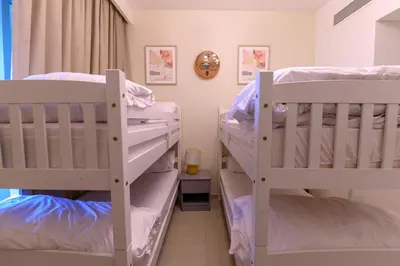 two white bunk beds in a room at Stunning Apartment - Downtown View 2 - Tower 1 - Fountain and Burj Khalifa view 61st floor in Dubai