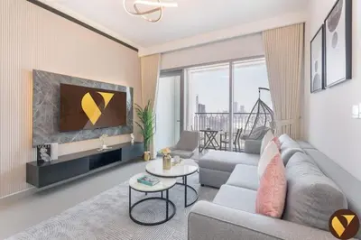 a living room with a couch and a table at Vogue Downtown Views II with Direct Access to Dubai Mall Via a Climate Controlled Bridge, One Bedroom Apartment with Balcony and City View in Dubai