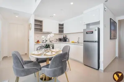 a kitchen with a table and chairs and a refrigerator at Vogue Downtown Views II with Direct Access to Dubai Mall Via a Climate Controlled Bridge, One Bedroom Apartment with Balcony and City View in Dubai