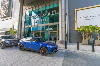 a blue car parked in front of a building at Vogue Downtown Views II with Direct Access to Dubai Mall Via a Climate Controlled Bridge, One Bedroom Apartment with Balcony and City View in Dubai