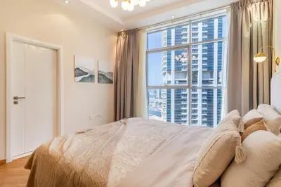 a bedroom with a bed and a large window at Marina Escape Spacious Skyview 2BR in Dubai