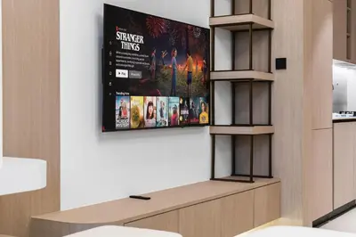 a tv hanging on a wall in a room at SettlerHomes - Chic JVC Studio - Pool & Clubhouse in Dubai