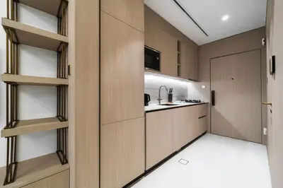 a kitchen with wooden cabinets and a kitchenasteryasteryasteryasteryasteryasteryasteryastery at SettlerHomes - Chic JVC Studio - Pool & Clubhouse in Dubai