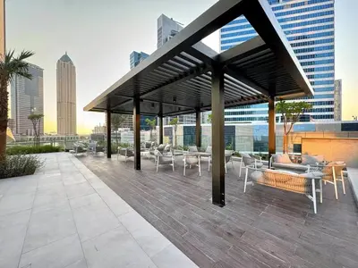a rooftop patio with tables and chairs on a building at Luxurious view of the Business Bay canal, 2 beds in Dubai