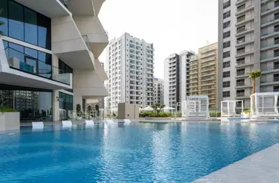 a large swimming pool in a building with tall buildings at Vogue JVC Binghatti Phantom near Circle Mall, One Bedroom Apartment with a Private Pool in Balcony and full Access to all Amenities in Dubai