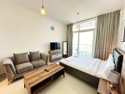 a living room with a bed and a couch at Cozy Studio Retreat in Damac Hills in Dubai
