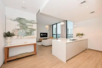an open kitchen and living room with a couch at Belgravia Heights 1 BHK in JVC in Dubai
