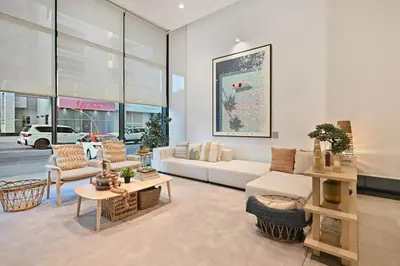 a living room with a white couch and chairs at Belgravia Heights 1 BHK in JVC in Dubai