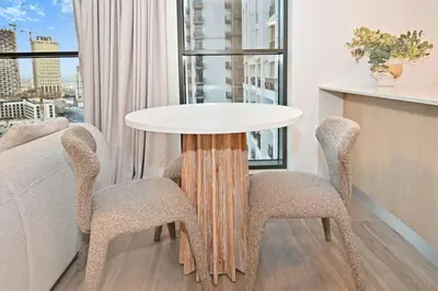 a table and two chairs in a room with a window at Belgravia Heights 1 BHK in JVC in Dubai