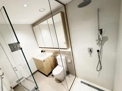 a bathroom with a shower and a toilet and a sink at Belgravia Heights II 1 BHK in JVC Luxury Living in Dubai